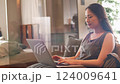 Woman operating a laptop on a sofa Camerawork 124009641