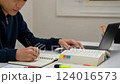 A working man is studying for a qualification exam 124016573