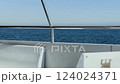 close-up of railings and seats on the upper deck of a boat swaying on the waves with a blue sea in the background 124024371