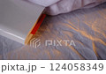 A compact pocket-sized white printer on bed prints polaroid style photo with orange colour in minimalist design modern technology creative process cozy atmosphere vibrant details portable convenience 124058349