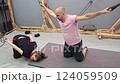 Kinesiotherapy session, patient performing assisted back stretching exercises 124059509