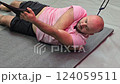 Bald man performing suspension training exercises for rotator cuff 124059511