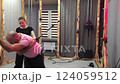 Personal trainer guiding man exercising with cable machine 124059512