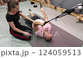 Physiotherapist assisting patient doing suspension training exercises 124059513