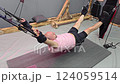 Bald man performing suspension training with leg abduction 124059514