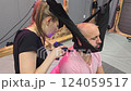 Physiotherapist using vibrating massage gun on patient's back 124059517