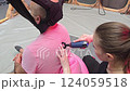 Physiotherapist using vibrating massage gun on patient's back 124059518
