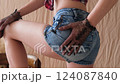 Woman wearing jean shorts and black gloves 124087840