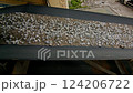 Conveyor belt transporting gravel and soil at a construction site. Industrial equipment for material handling in a quarry or mining operation. Manufacturing and construction process photography 124206722