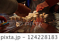 Close-up of hands lighting tea candles on a reflective surface. Group participation in a remembrance or community ceremony. Symbolic act of unity, prayer, and tribute 124228183