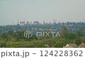 Industrial steel plant with smokestacks emitting smoke and fire behind a green residential area with houses and trees. Environmental pollution and heavy industry concept 124228362