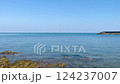 A video of a landscape of a calm sea and blue sky, the surface of the rippling sea, a red pole standing on the surface of the sea 124237007