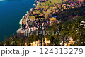 Stunning view of a lakeside village from above while riding a cable car during daylight in the Alps 124313279