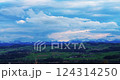 Scenic view of rolling hills and mountains under a dramatic sky in the countryside 124314250