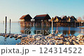 Scenic lakeside village with stilt houses reflecting in the water at sunrise 124314522