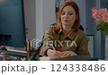 Woman taking notes during an online meeting in her home office 124338486