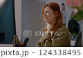 Woman experiences neck pain while working from home at her office 124338495