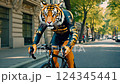 sporty anthropomorphic tiger rides a bicycle around the city 124345441