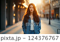 Young Woman in Denim Jacket at Sunset on City Street 124376767