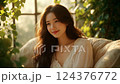 Young Woman in White Lace Blouse, Golden Sunlight, Green Foliage 124376772