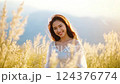 Smiling Woman in Beige Grass Field at Sunset 124376774