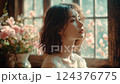 Profile Portrait of a Young Woman by Window with Pink Roses 124376775