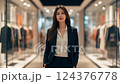 Confident Young Businesswoman in Black Suit Poses in Modern Retail Store 124376778