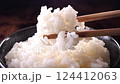 Lift up the steaming rice with chopsticks 124412063
