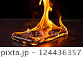 A smartphone engulfed in flames with smoke rising against a dark background. The image conveys a sense of technological malfunction and danger. 124436357