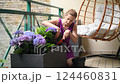 Woman planting purple hydrangea on the balcony 124460831