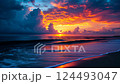 Vibrant sunset waves reflecting fiery clouds over tranquil ocean shoreline 124493047