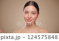 Portrait young woman uses creams of her face. Concept for fresh moisturized skin beautiful closeup cosmetic face happy healthy model.   Model with a bottle of face cream. Slow motion 124575848