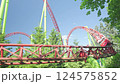 Roller coaster Ride against blue sky. Roller coaster in the amusement park. Cheerful entertainments in park of attractions 124575852