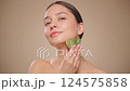 Beauty young woman doing skin care routine, scrapping, massage facial skin with jade gua sha scrapper, Facial treatment for anti aging and cosmetic cleaning. Slow motion 124575858