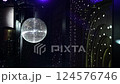 A mirrored disco ball reflects light rays throughout the room. Smoke enhances the visibility 124576746