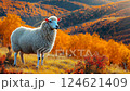 Sheep grazing in a vibrant autumn landscape with golden foliage in the background 124621409