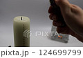 A woman's hand lights a Christmas advent candle whith numbers. Christmas decor and holiday preparations 124699799