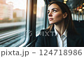 young woman businesswoman in suit riding modern train and looking out the window. 124718986
