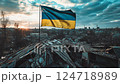 Ukrainian flag on the roof of a destroyed house overlooking the city 124718989