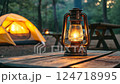 tent, lantern on wooden table in campsite. 124718995