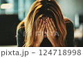 Stressed businesswoman in office feeling depressed covering face with hands 124718998