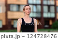 Serene female practicing deep breathing near verdant greenery, experiencing mindful meditation amid natural landscape with calm, centered posture 124728476