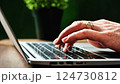 A scene of typing on a laptop keyboard in a study 124730812