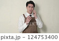 A Japanese man in an apron giving an explanation on the phone 124753400