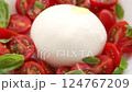 Pouring Olive Oil on to Fresh Burrata Cheese With Cherry Tomatoes and Basil  124767209