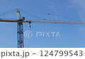 Tower Crane Hoisting at Construction Site Panning Under Blue Sky 124799543