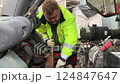 Car mechanic repairs a forklift. Mechanic services a car engine. 124847647