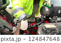 Car mechanic repairs a forklift. Mechanic services a car engine. 124847648