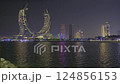 Lusail city, Qatar-March 20 2025: Katara Hospitality Tower, Crescent Tower, or Lusail Katara Hotel North Tower at night showing the unique architecture of the illuminated tower with Lusail marina  124856153