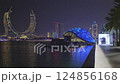 Lusail city, Qatar-March 20 2025: Katara Hospitality Tower, Crescent Tower, or Lusail Katara Hotel North Tower at night showing the unique architecture of the illuminated tower with Lusail marina  124856168